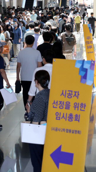 21일 서울 삼성동 코엑스에서 한남3구역 재개발 조합이 강남구청의 집함금지 행정명령에도 시공자 선정을 위한 조합원 임시총회를 강행했다. 조합원들이 총회장에 들어가기 위해 줄을 길게 늘어서 있다. 연합뉴스