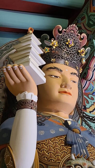사천왕들의 수장으로 북방을 지키는 다문천왕의 세부. 준수한 청년 얼굴을 한 신상이 보탑을 들고 있다.
