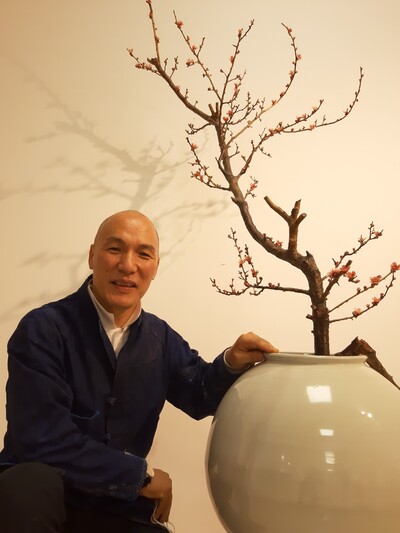 윤회매 가지를 담은 백자 화병 옆에 앉아 이야기하고 있는 김창덕 작가. 사진 노형석 기자 윤회매 가지를 담은 백자 화병 옆에 앉아 이야기하고 있는 김창덕 작가. 사진 노형석 기자