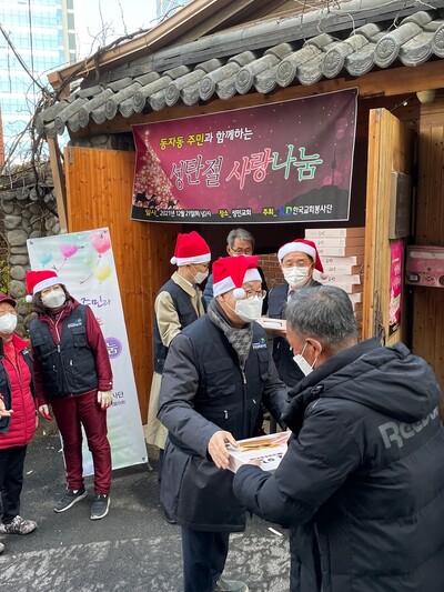 한국교회봉사단이 성탄절을 앞두고 지난 21일 서울 동자동 성민교회 앞에서 연 사랑나눔 행사에서 주민들에게 선물을 전달하고 있다. 한국교회봉사단 제공