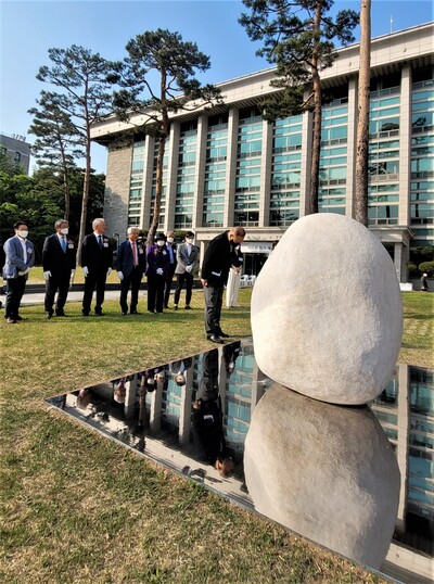 거장 이우환 작가의 신작 <관계항> 제막식에서 전시기획자인 이용우 전 고려대 교수가 맨앞에 나와 바닥의 거울을 들여다보고 있다. 노형석 기자