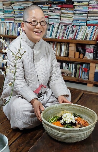 지난 22일 서울 관악산 자락 낙성대 길상사에서 정위 스님이 손수 장만한 갖은 야채에 뒷뜰에서 갓따온 꽃송이로 고명을 올린 매화꽃비빔밥을 차려내 보이고 있다. 사진 김경애 기자