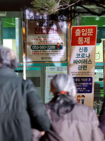 19일 오후 대구시 서구 중리동 대구의료원 선별진료소 앞을 시민들이 지나가고 있다. 연합뉴스