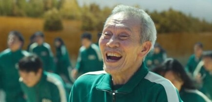 넷플릭스 &lt;오징어 게임&gt; ‘무궁화꽃이 피었습니다’ 게임 장면에서 오영수가 해사한 웃음을 지으며 결승점을 넘고 있다. 영화 &lt;오징어 게임&gt; 갈무리
