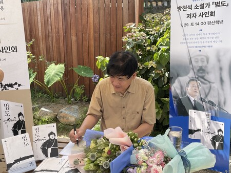 독립운동가 홍범도 장군의 일대기를 그린 소설 ‘범도’의 방현석 작가가 29일 오후 경남 양산 평산책방에서 열린 작가 사인회에서 책에 인사말과 서명을 적고 있다.