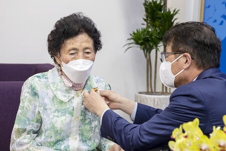 김태엽 서귀포시장이 부금현 할머니에게 대통령표창을 달아주고 있다. 삼육대 제공