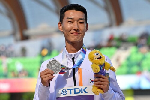 우상혁이 은메달과 인형을 들고 포즈를 취하고 있다. 유진/AFP 연합뉴스