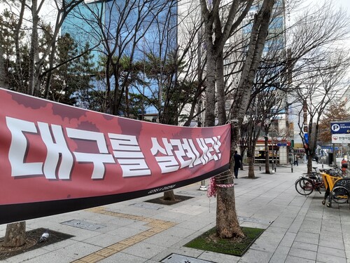 지난달 26일 오후 대구 중구 2·28기념중앙공원 앞에 ’대구를 살려내라‘는 펼침막이 걸려있다.