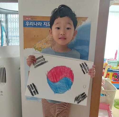 전현주씨의 4살 아들이 직접 그린 태극기 그림을 들고 있다. 전현주씨 제공