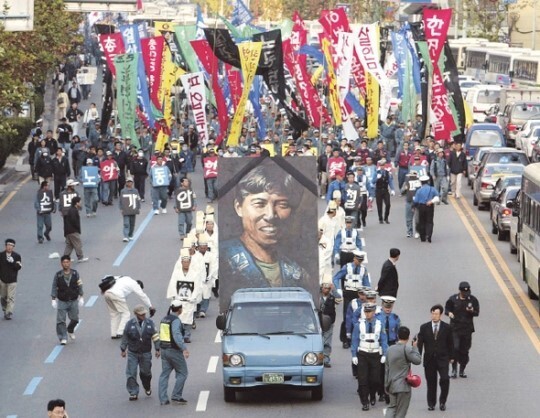 2003년 10월22일 부산에서 고 김주익·곽재규씨 영결식이 끝난 뒤 참가자들이 김주익씨의 대형 영정을 따라 시내를 행진하고 있다. 한겨레 자료사진