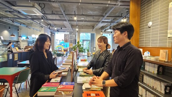 ‘로컬씨, 어디에 사세요?’를 쓴 작가 서진영씨(왼쪽)와 책을 구상하고 기획한 온다프레스 박대우 대표(오른쪽 앞)와 이나래 문화도시 콘텐츠피디가 서울 망원동 카페창비에서 책에 관한 이야기를 하며 환하게 웃고 있다. 양선아 기자