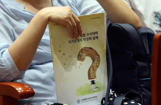 서울시교육연구정보원 주최로 열린 입시 설명회 ‘대입 수시대비 자기소개서 작성의 실제’에서 한 참석자가 안내물을 들고 있다. 연합뉴스 서울시교육연구정보원 주최로 열린 입시 설명회 ‘대입 수시대비 자기소개서 작성의 실제’에서 한 참석자가 안내물을 들고 있다. 연합뉴스