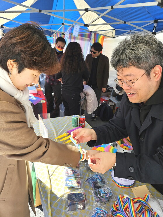 가톨릭 성소수자 지지단체 아르쿠스 회원 이전수(오른쪽)씨가 제3회 경남퀴어문화축제 참가자의 손목에 무지개 리본을 매어주고 있다. 최상원 기자