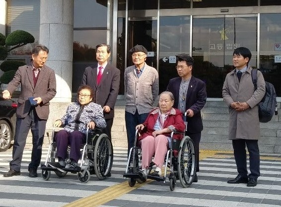 고인(휠체어 앉은 오른쪽)과 양금덕(왼쪽) 할머니가 2018년에 미쓰비시중공업을 상대로 낸 손해배상 소송 항고심에서 승소하고 광주고등법원 현관 앞에서 사진을 찍었다. 장헌권 목사 제공