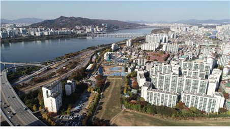 풍납토성 서쪽 성벽 복원지구 발굴조사 현장을 공중에서 내려다본 모습. 왼쪽 한강변을 배경으로 강변도로가 보이고 그 안쪽으로 사진 중앙부 하단의 길쭉한 공터가 서쪽 성벽의 자취가 확인된 조사지역이다. 과거 삼표 시멘트 공장이 있던 곳으로 현재는 철거되고 역사공원 정비사업이 진행될 예정이다.