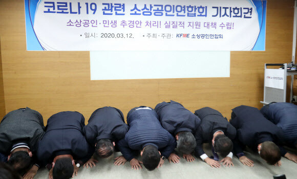 12일 서울 동작구 소상공인연합회에서 열린 코로나19 소상공인 피해 사례 관련 긴급 기자회견에서 참석자들이 생존권 보장을 촉구하며 큰절을 하고 있다. 연합뉴스