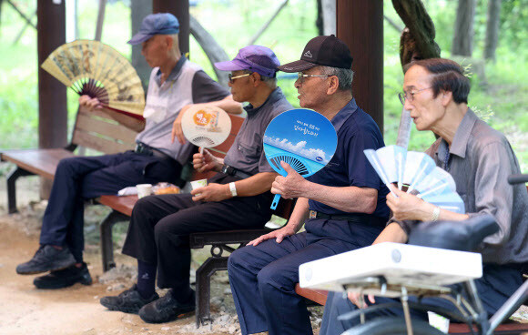 창원지역에 폭염경보가 발효된 지난 26일 오후 경남 창원시 마산합포구 3·15해양누리공원에서 시민들이 부채질을 하며 더위를 식히고 있다. 연합뉴스