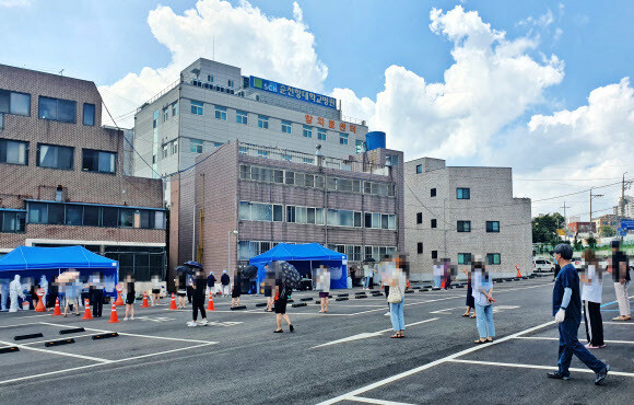 순천향대 천안병원 직원들이 코로나19 검사를 받기 위해 병원에서 줄을 서 대기하고 있다. 이 병원 간호사 등 의료진 3명이 코로나19 확진 판정을 받았다. 연합뉴스