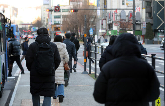 서울에 한파 경보가 내려진 30일 아침 서울 광화문네거리에서 롱패딩으로 중무장한 시민이 횡단보도로 걸어가고 있다. 연합뉴스