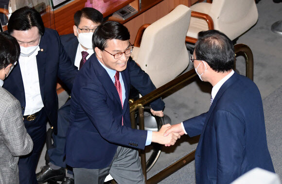 국민의힘 윤상현 의원이 지난 20일 국회에서 열린 본회의에서 대정부질문을 마친 뒤 주호영 원내대표와 악수하고 있다. 공동취재사진