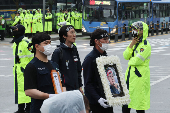 지난 5월1일 노동절에 분신해 숨진 건설노동자 양회동씨의 장례행렬이 21일 오전 서울대병원 장례식장에서 발인 미사를 마친 뒤 노제가 열린 서울 서대문구 경찰청 방향으로 이동하고 있다. 신소영 기자 viator@hani.co.kr