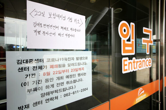 지난 22일 코로나19 확진자가 발생한 광주김대중컨벤션센터에 행사 취소를 알리는 안내문이 붙어 있다. 연합뉴스 지난 22일 코로나19 확진자가 발생한 광주김대중컨벤션센터에 행사 취소를 알리는 안내문이 붙어 있다. 연합뉴스