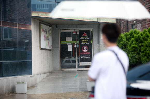 광주광역시가 14일 사회적 거리두기를 2단계로 조정했다. 사진은 13일 오전 광주 서구 한 교회에서 담당 공무원이 점검을 위해 출입문을 지켜보고 있는 모습. 연합뉴스