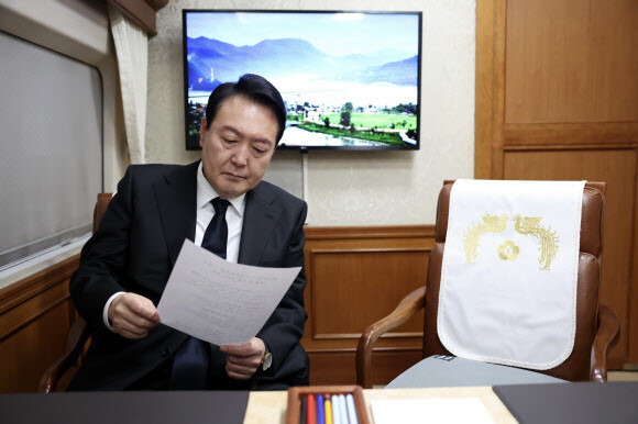 윤석열 대통령이 18일 오전 제42주년 5·18 광주민주화운동 기념식에 참석하기 위해 서울역에서 KTX 특별열차에 탑승해 자료를 검토하고 있다. 공동취재사진 윤석열 대통령이 18일 오전 제42주년 5·18 광주민주화운동 기념식에 참석하기 위해 서울역에서 KTX 특별열차에 탑승해 자료를 검토하고 있다. 공동취재사진