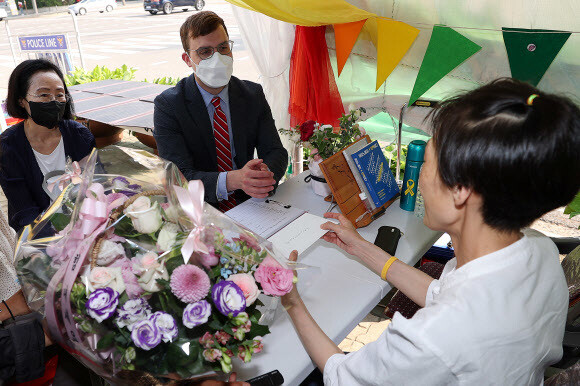 주한미국 대사관 세스 윈고우스키 서기관(가운데)이 23일 낮 서울 영등포구 국회 앞 차별금지법제정연대(차제연) 단식 농성장에 방문해 미류 차제연 책임집행위원(오른쪽)과 대화를 나누고 있다. 이날 윈고우스키 서기관은 미국·캐나다·호주·영국 대사관의 서기관과 함께 쓴 서한을 전달했다. 연합뉴스