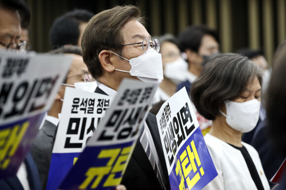 이재명 더불어민주당 의원이 11일 오후 국회에서 열린 의원총회에서 동료 의원들과 함께 윤석열 정부를 규탄하는 피켓을 들고 있다. 공동취재사진