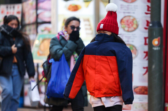 “한국 너무 추워요” 강추위가 이어진 20일 오후 서울 중구 명동거리에서 한 외국인 관광객 어린이가 외투 안으로 팔을 모으고 있다. 연합뉴스