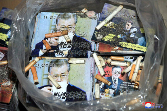 북한이 대규모 대남삐라(전단) 살포를 위한 준비를 본격적으로 추진 중이라고 조선중앙통신이 20일 보도했다. 컵을 들고 무엇인가를 마시는 문재인 대통령 얼굴에 ''다 잡수셨네…북남합의서까지''라는 문구를 넣은 ''대남삐라'' 위에 담배꽁초를 던져넣은 모습이다. 연합뉴스