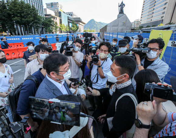 서울시가 광화문 광장 재구조화 공사를 위해 광장에 있는 ‘세월호 기억공간’ 철거를 예고한 26일 오전, 세월호 기억공간 입구에서 서울시 김혁 총무과장(왼쪽)이 김선우 4·16연대 사무처장에게 철거와 관련한 입장을 전달하고 있다. 연합뉴스