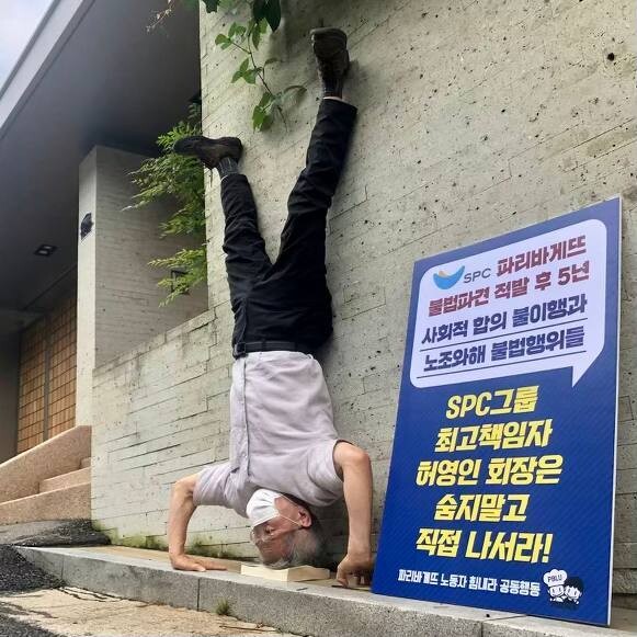 파리바게뜨 노동자 힘내라 공동행동 주최로 ‘SPC 불매’ 두 번째 1인 시위가 열린 23일, 공동행동 대표를 맡고 있는 권영국 변호사가 서울 용산구 한남동 허영인 SPC 회장 집 앞에서 물구나무를 선 채 1인시위를 하고 있다. 권 변호사는 더 많은 이들에게 파리바게뜨 사태와 SPC 불매 운동 동참을 요청하는 차원에서 관심을 환기하고자 물구나무 시위를 한다고 설명했다. 파리바게뜨 노동자 힘내라 공동행동 제공.