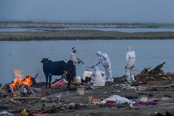 방역복을 입은 이들이 지난 5일 인도 갠지스 강가에서 코로나19 희생자를 화장하기 위해 준비하고 있다. 가르흐무크테슈와르/AFP 연합뉴스