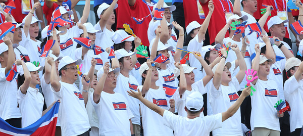 30일 중국 원저우 스포츠센터 스타디움에서 열린 2022 항저우아시안게임 여자축구 8강전 한국과 북한의 경기에서 북한 응원단이 깃발을 흔들고 있다. 항저우/연합뉴스