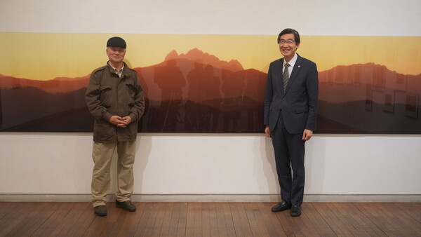 전민조 작가와 연규홍 총장이 13일 갤러리에서 가장 큰 작품인 폭 6미터짜리 사진 ‘벽제’(1979년) 앞에서 나란히 섰다. 한신대 제공