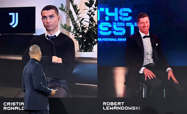 바이에른 뮌헨의 로베르트 레반도프스키(오른쪽)가 18일(한국시각) 열린 국제축구연맹(FIFA) 어워즈 2020 행사에서 크리스티아누 호날두가 지켜보는 가운데 올해의 선수상을 받고 있다. 취리히/로이터 연합뉴스