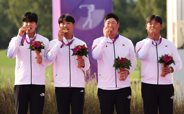 한국 남자골프대표팀의 장유빈(왼쪽부터) 조우영, 임성재, 김시우가 1일 중국 항저우 서호 국제 골프코스에서 열린 2022 항저우아시안게임 단체전 시상대에서 금메달을 깨물고 있다. 항저우/연합뉴스