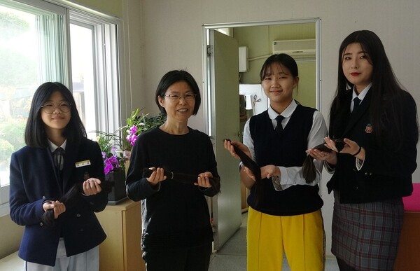 목포항도여중 최민아 학생(왼쪽부터), 방주현 교사,  부예선·박신혜 학생이 소아암 환자들을 돕기 위해 기부한 머리카락을 들고 있다. 사진 목포항도여중