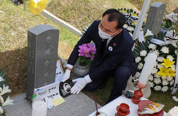 5일 광주 국립5·18민주묘지에서 전재수군의 큰형 재룡씨가 동생의 영정사진을 어루만지고 있다. 김용희 기자 kimyh@hani.co.kr