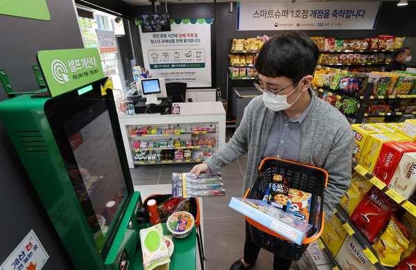 15일 오후 서울 동작구 형제슈퍼가 ‘스마트슈퍼’ 1호점으로 개점해 관계자가 무인 계산대를 이용해 물품을 사는 과정을 시연하고 있다. 연합뉴스