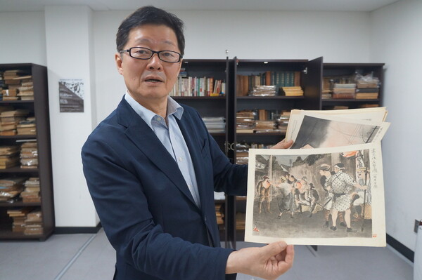 이규수 교수가 고 강덕상 교수 기증 자료인 간토대지진 당시 모습을 새긴 목판화를 들어보이고 있다. 강성만 선임기자