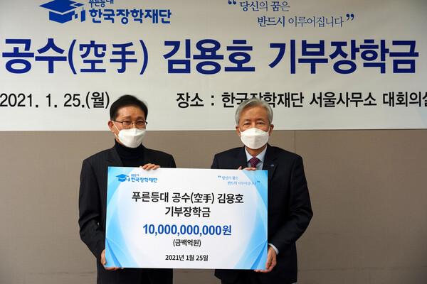김용호(왼쪽) 대표가 25일 오전 한국장학재단에 장학금 100억원을 기부한 뒤 이정우(오른쪽) 재단 이사장과 기념촬영을 하고 있다. 박경만 기자