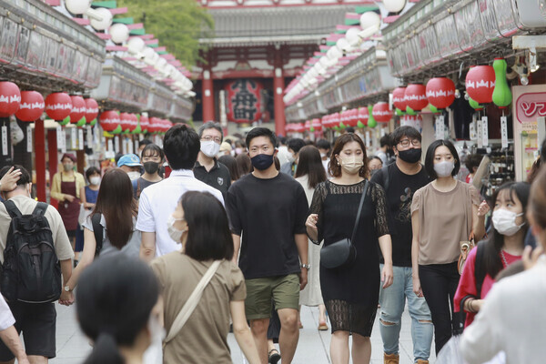 일본 도쿄 상점가에서 시민들이 마스크를 쓰고 걷고 있다. 도쿄/AP 연합뉴스