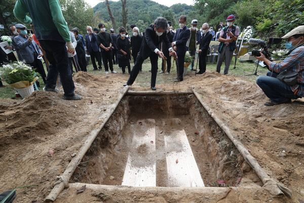 25일 오전 경기 남양주 모란공원 민주열사 묘역에서 문익환·박용길, 유원호·안순심 부부의 묘를 지난 4월 유골로 귀국해 묻힌 정경모 선생의 묘역 옆으로 옮기는 이장행사가 열렸다. 이번 행사는 문익환 목사의 부인 박용길 장로의 10주기 기일에 맞춰 열렸다. 문성근씨가 이장된 문익환·박용길 부부 묘에 흙을 뿌리고 있다. 남양주/박종식 기자 anaki@hani.co.kr