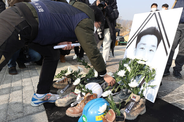 지난해 1월10일 오전 서울 종로구 청와대 분수대 앞에서 열린 ‘고 김다운 전기노동자 산재사망 추모 및 위험을 외주화한 한전을 규탄하는 기자회견’에서 참석자들이 영정에 헌화하고 있다. 연합뉴스