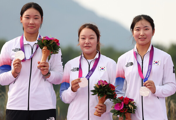 한국 여자골프대표팀의 김민솔(왼쪽부터)과 임지유, 유현조가 1일 중국 항저우 서호 국제 골프코스에서 열린 항저우아시안게임에서 단체전 은메달을 목에 걸고 기뻐하고 있다. 항저우/연합뉴스