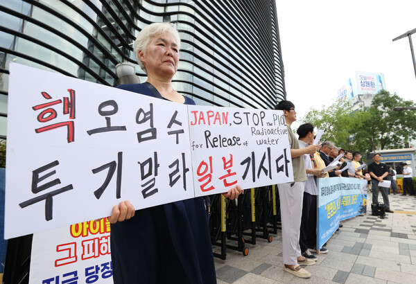 14일 오전 서울 종로구 일본대사관 앞에서 한국기독교교회협의회와 일본기독교협의회가 연 ‘후쿠시마 오염수 해양 투기 계획 철회 요구 기자회견’에서 한 참가자가 손팻말을 들고 있다. 연합뉴스