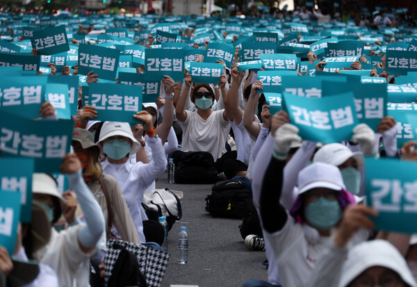 윤석열 대통령의 간호법 재의요구권 행사에 반발하며 19일 서울 중구 세종대로 일대에서 열린 ‘간호법 거부권 범국민 규탄대회’에 참석한 간호사들과 간호대학 학생 등이 손팻말을 들고 구호를 외치고 있다. 김혜윤 기자 unique@hani.co.kr